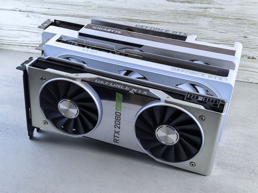 Three NVIDIA GeForce RTX graphics cards stacked on a surface, showcasing their sleek design and branding details.